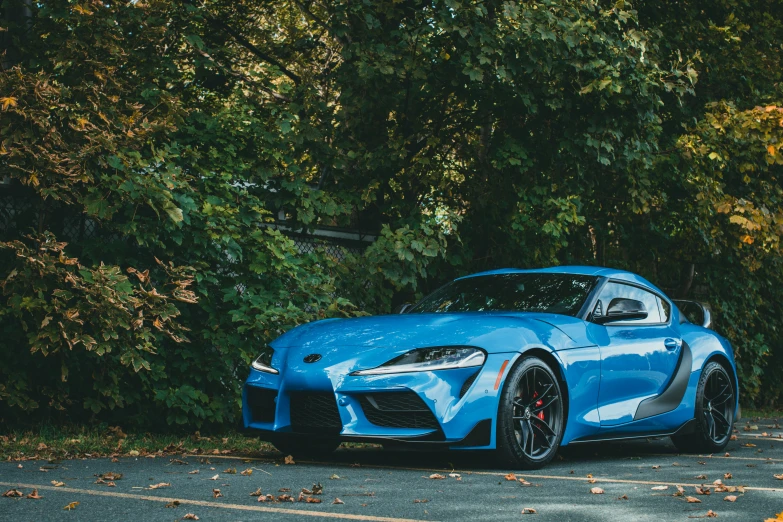 the new sports car in blue is parked on the street