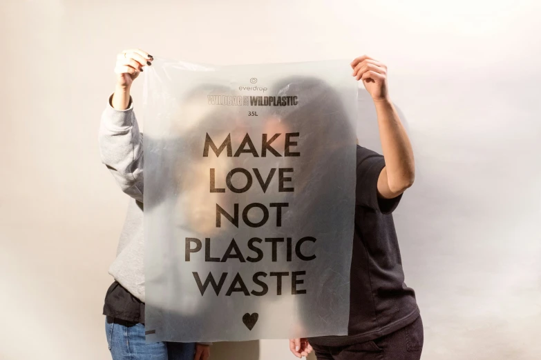 two people holding up a plastic bag with the words make love not plastic waste written on it