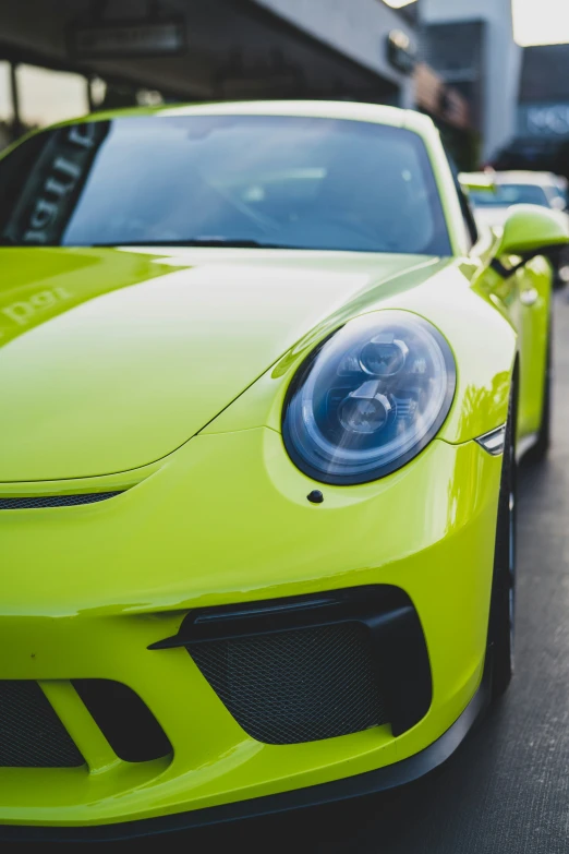 the front end of a yellow porsche sports car parked on a street