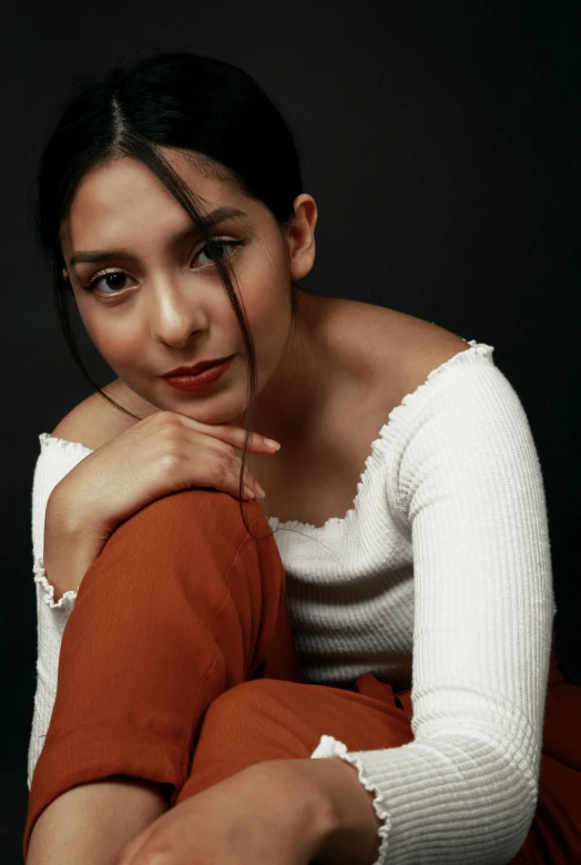 a woman sitting on the ground posing for the camera