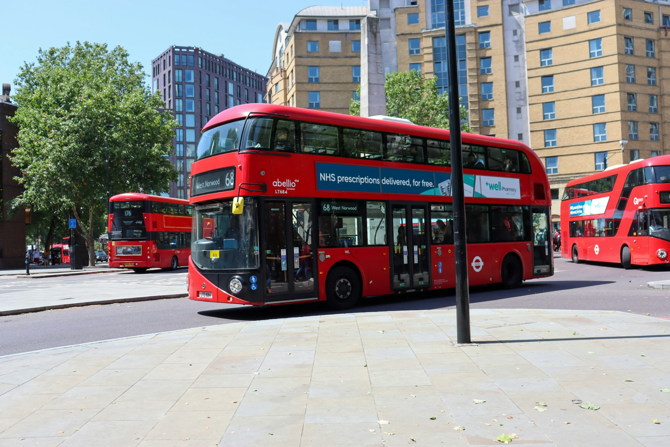 a couple of red double decked buses on a city street