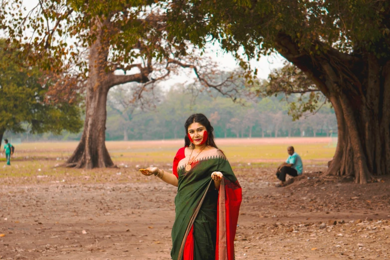 woman dressed in a green saree holding food