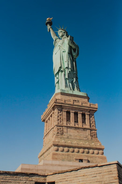 the statue of liberty is against a blue sky