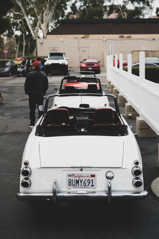 a white old car parked on the side of a road