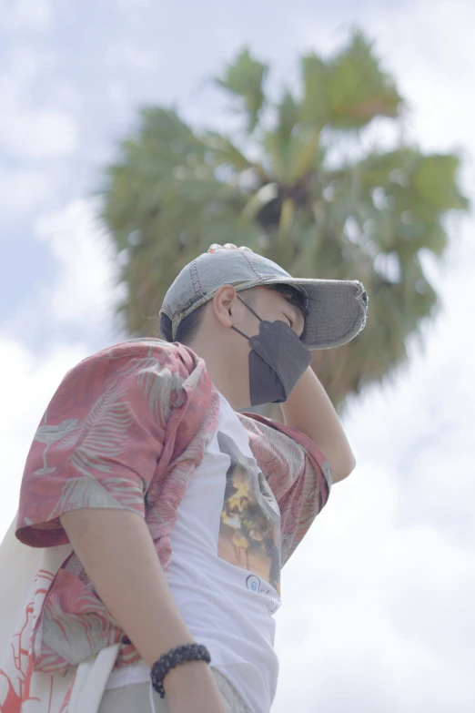 a boy with sun glasses and a cap talking on a cell phone