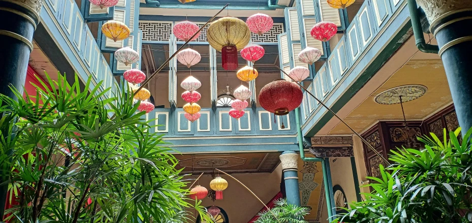 a hallway with hanging lanterns and a plant