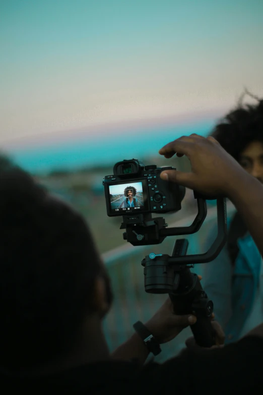 a man holds a video camera as a woman looks on