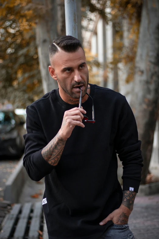 a man holding an electronic cigarette is on the street