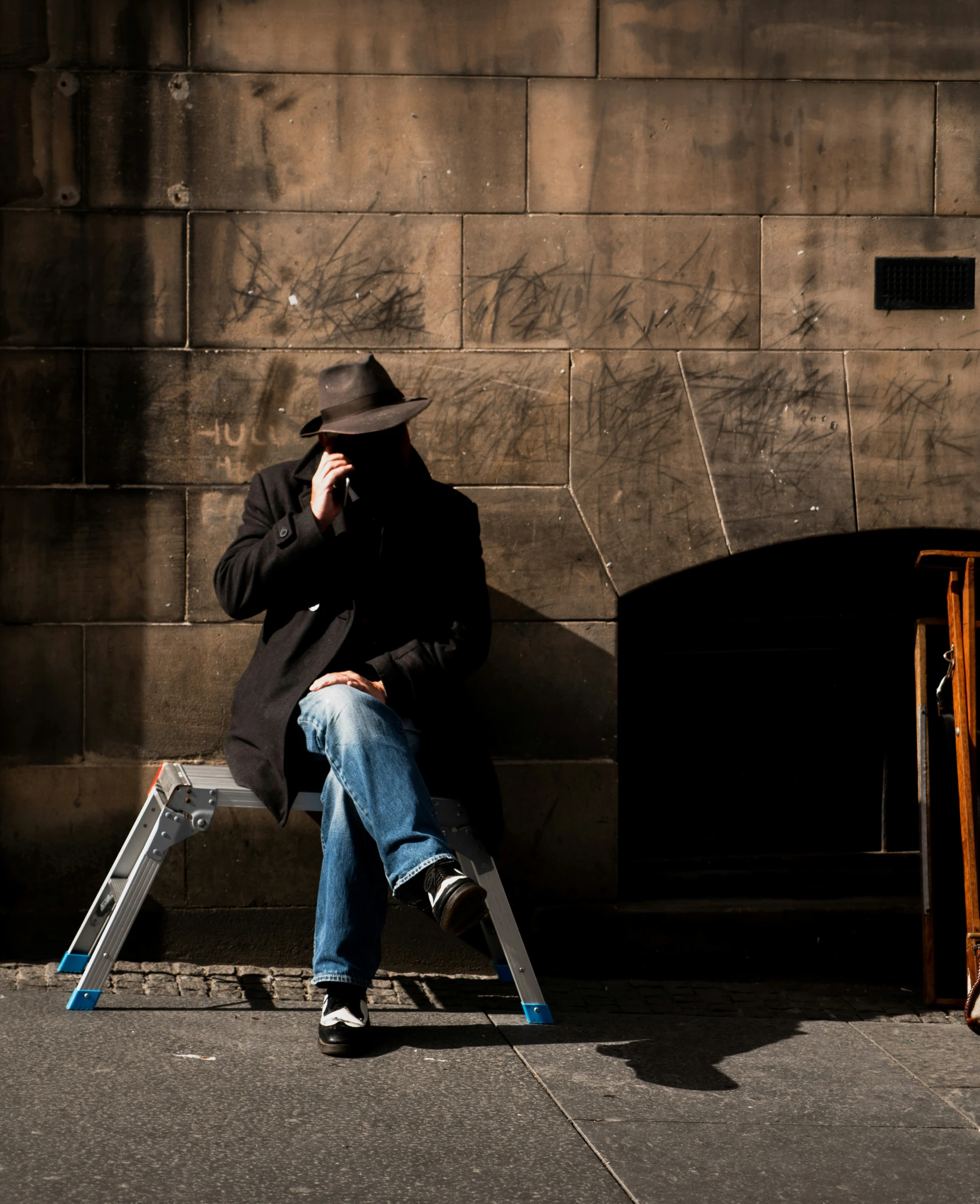 a man sitting on a bench with his head to his face