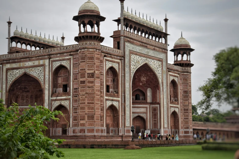 an elaborate brick building with some pillars and windows