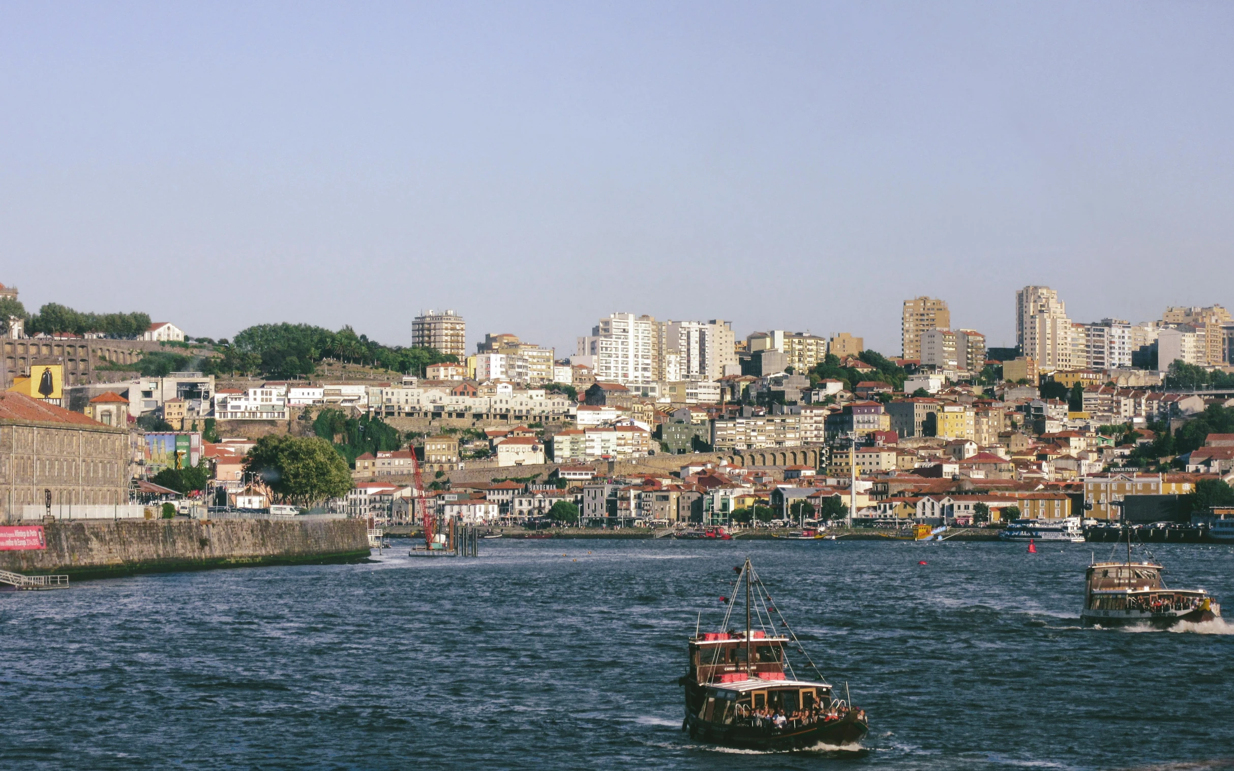 a city on the shore with ships moving on the water