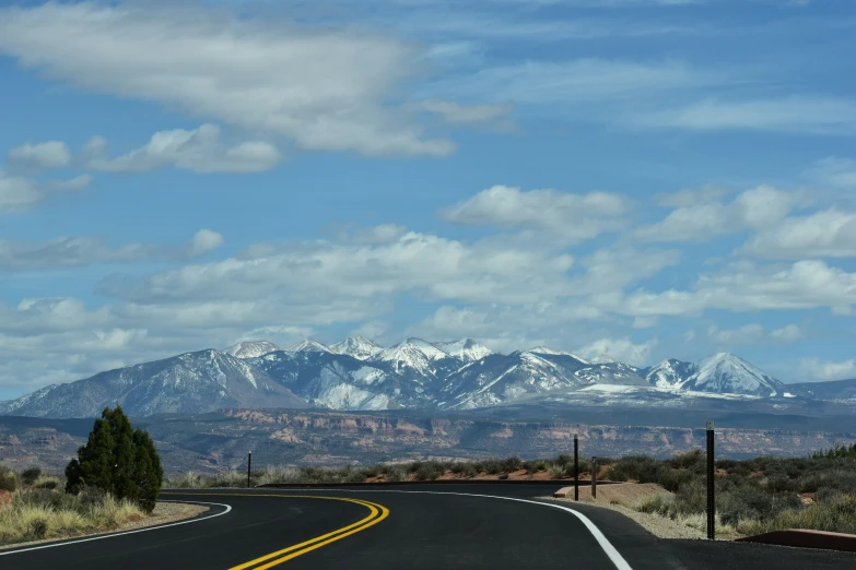 a long straight road with mountains in the background