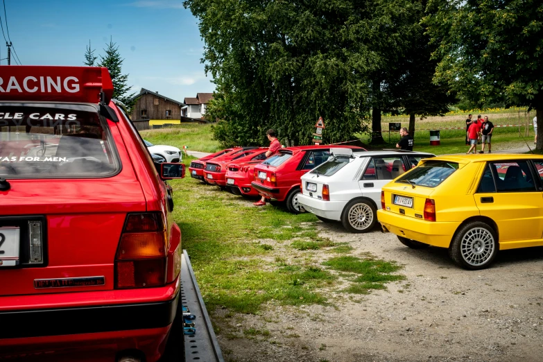 a bunch of colorful cars parked together at the car show