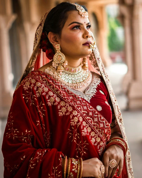 indian woman in traditional garb and jewelry looking up at soing