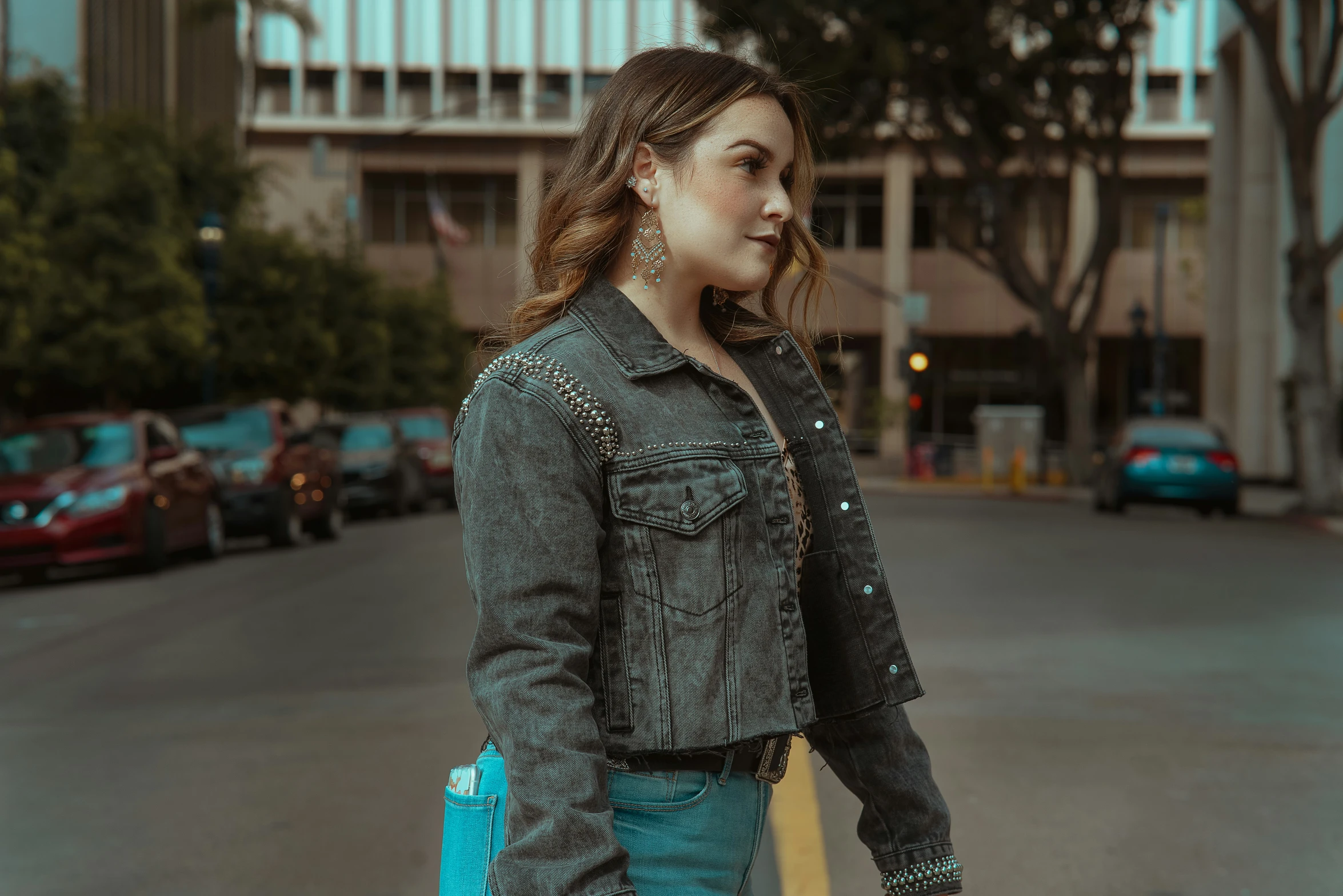 a woman is standing by the curb holding a surfboard