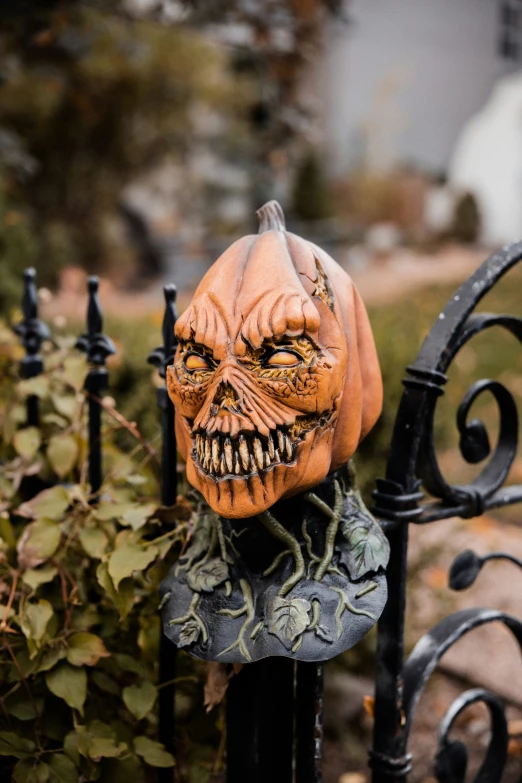 a creepy pumpkin head on top of a fence