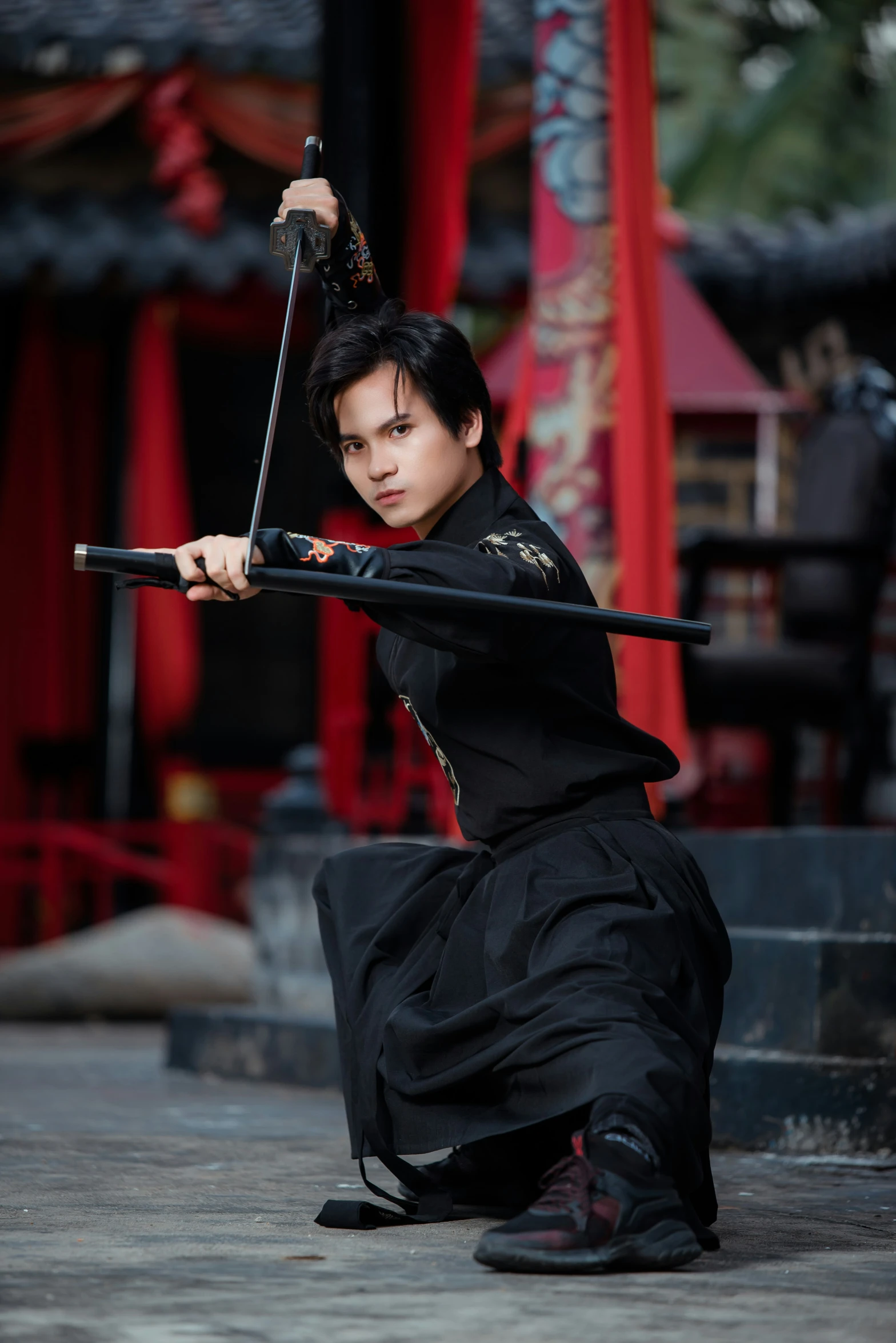 a man with a sword standing in front of a building