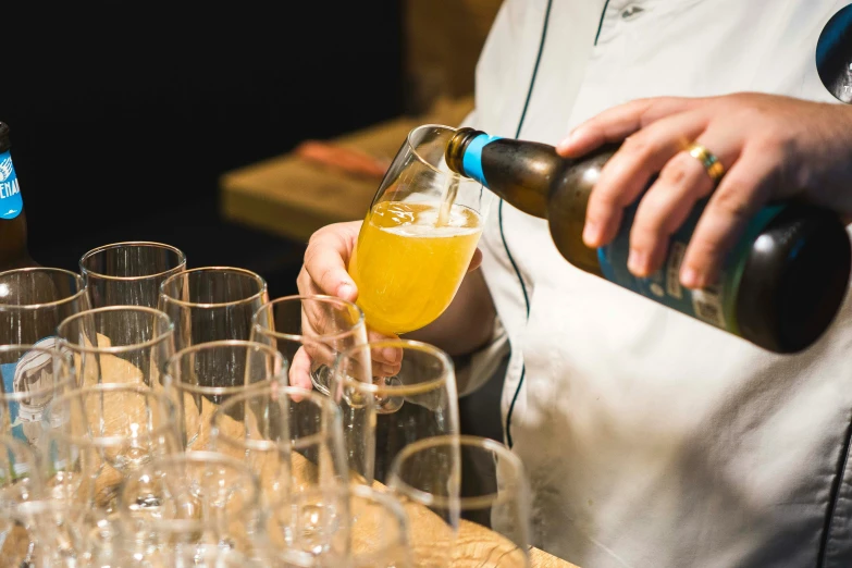 a bartender pours a drink into a glass