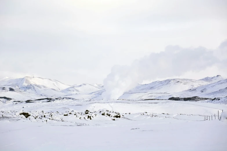 a snowy landscape with mountains and snow in the background