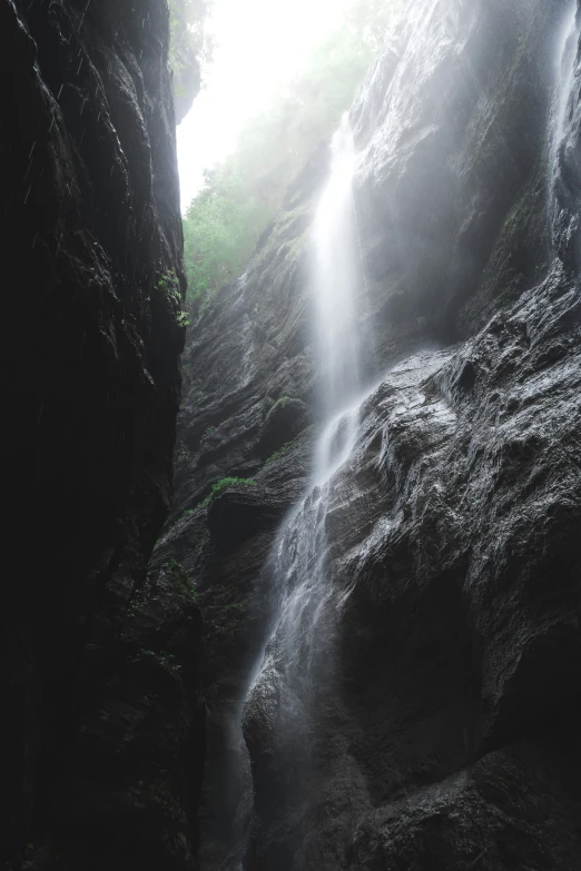 a man in a red jacket is standing next to a waterfall