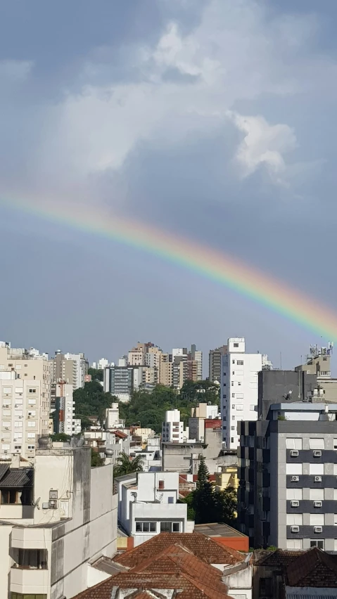 a rainbow shines above the city skyline