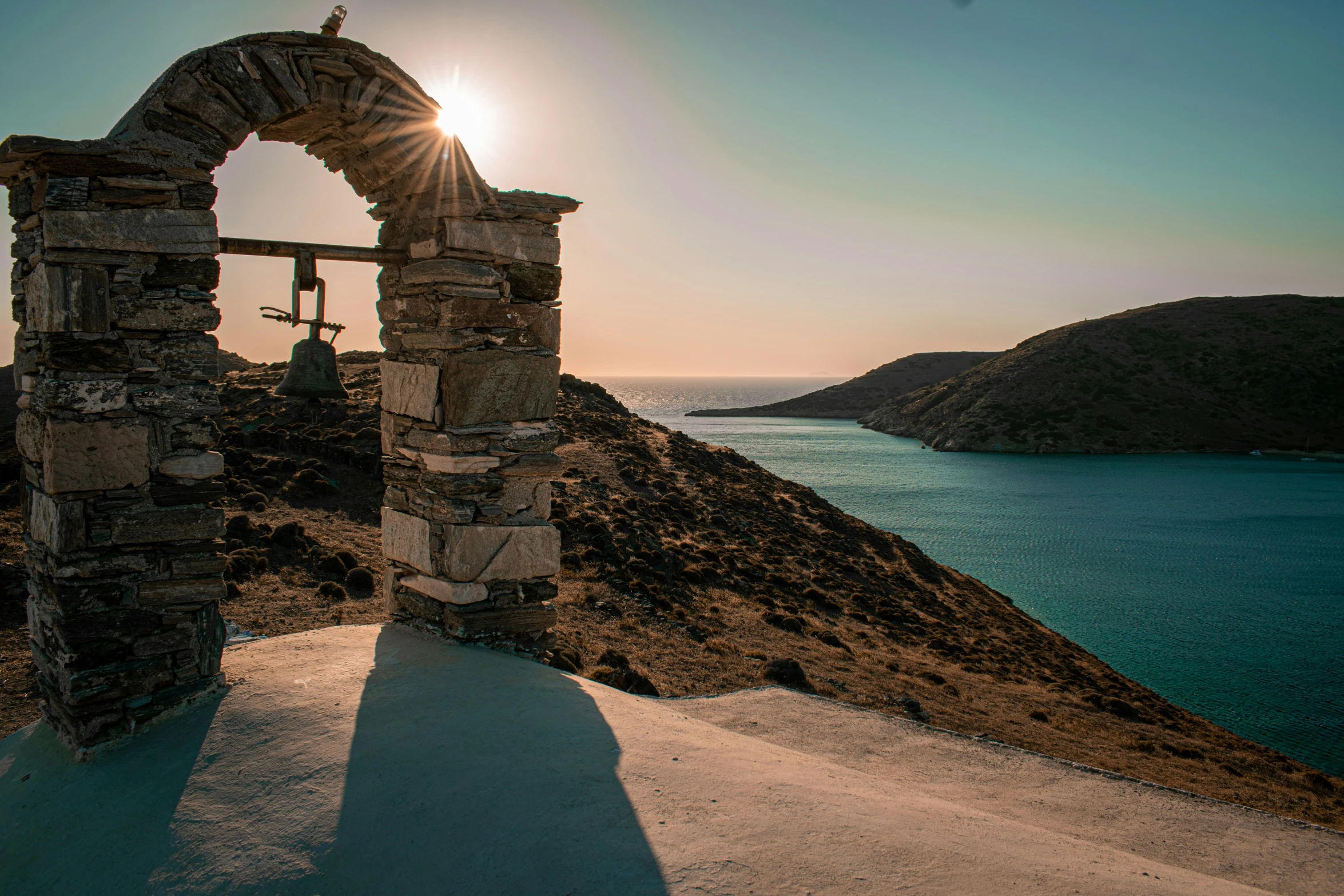 a small church tower by a beautiful lake