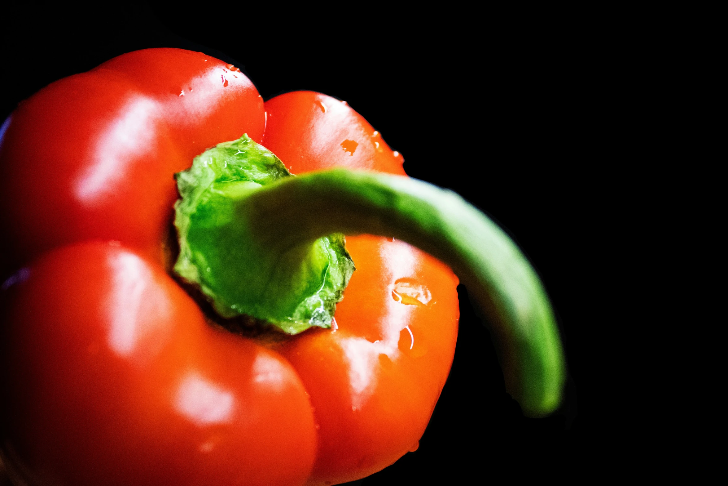 a large tomato with a bit of green stuff on top