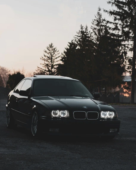 a black bmw parked in a parking lot
