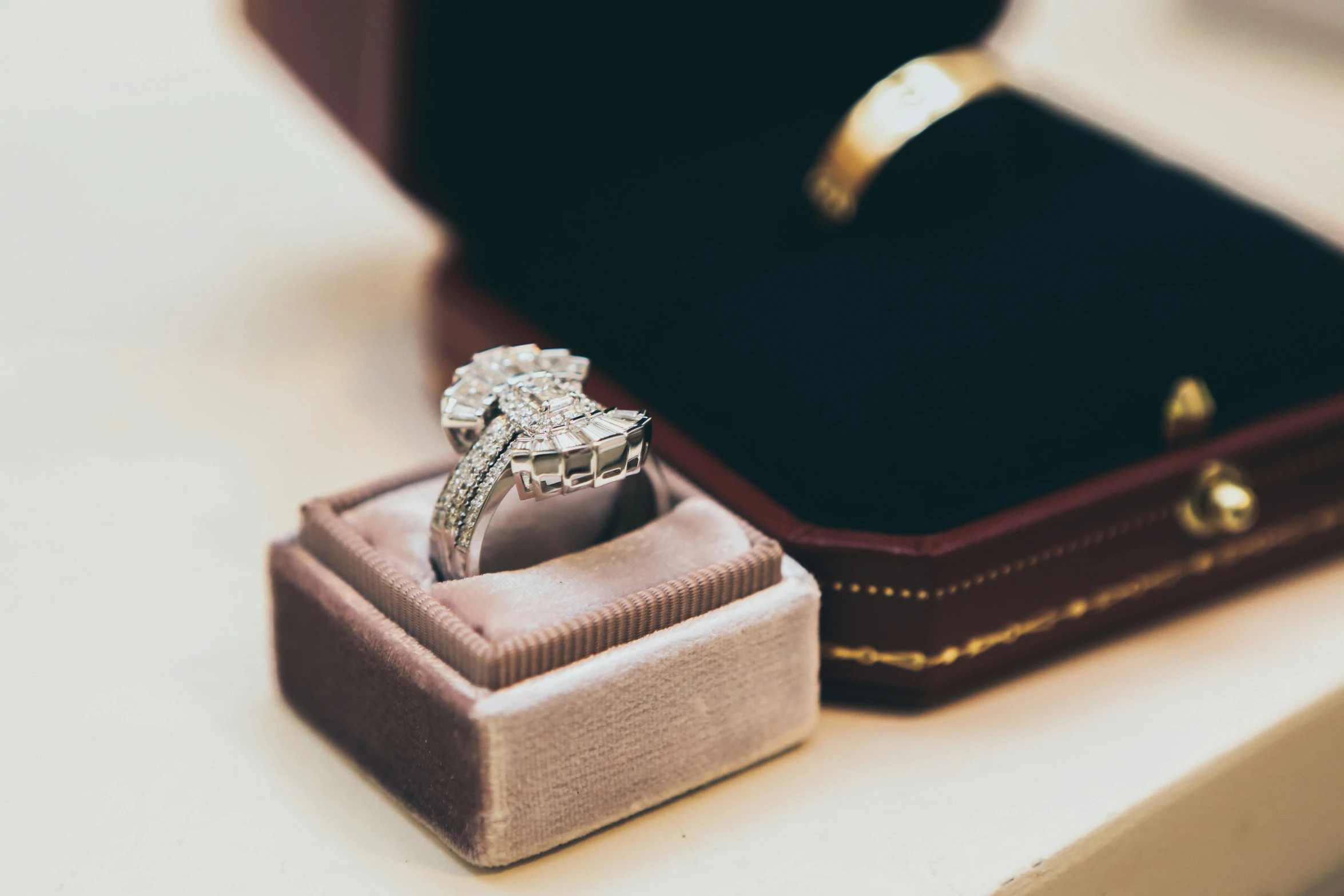 a white gold diamond ring next to a box