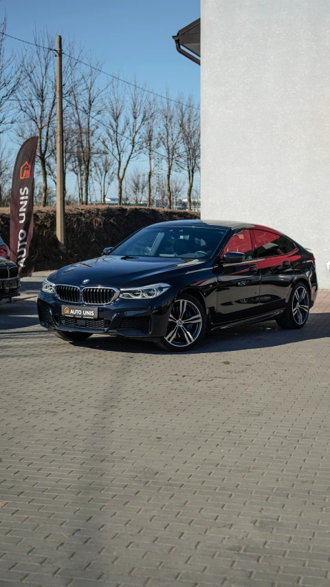 the bmw is parked in front of a white wall