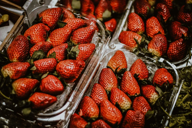 plastic containers filled with strawberries on top of a table