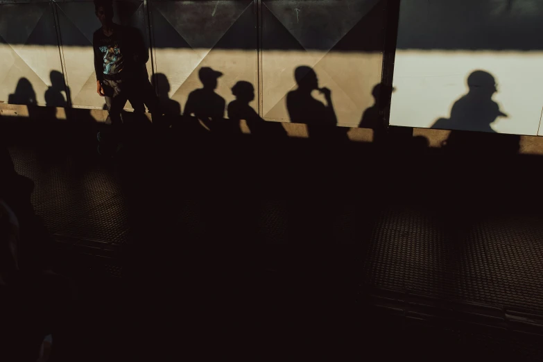 the shadow of a man walking next to a wall