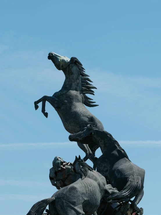 a statue of two horses with heads turned to each other