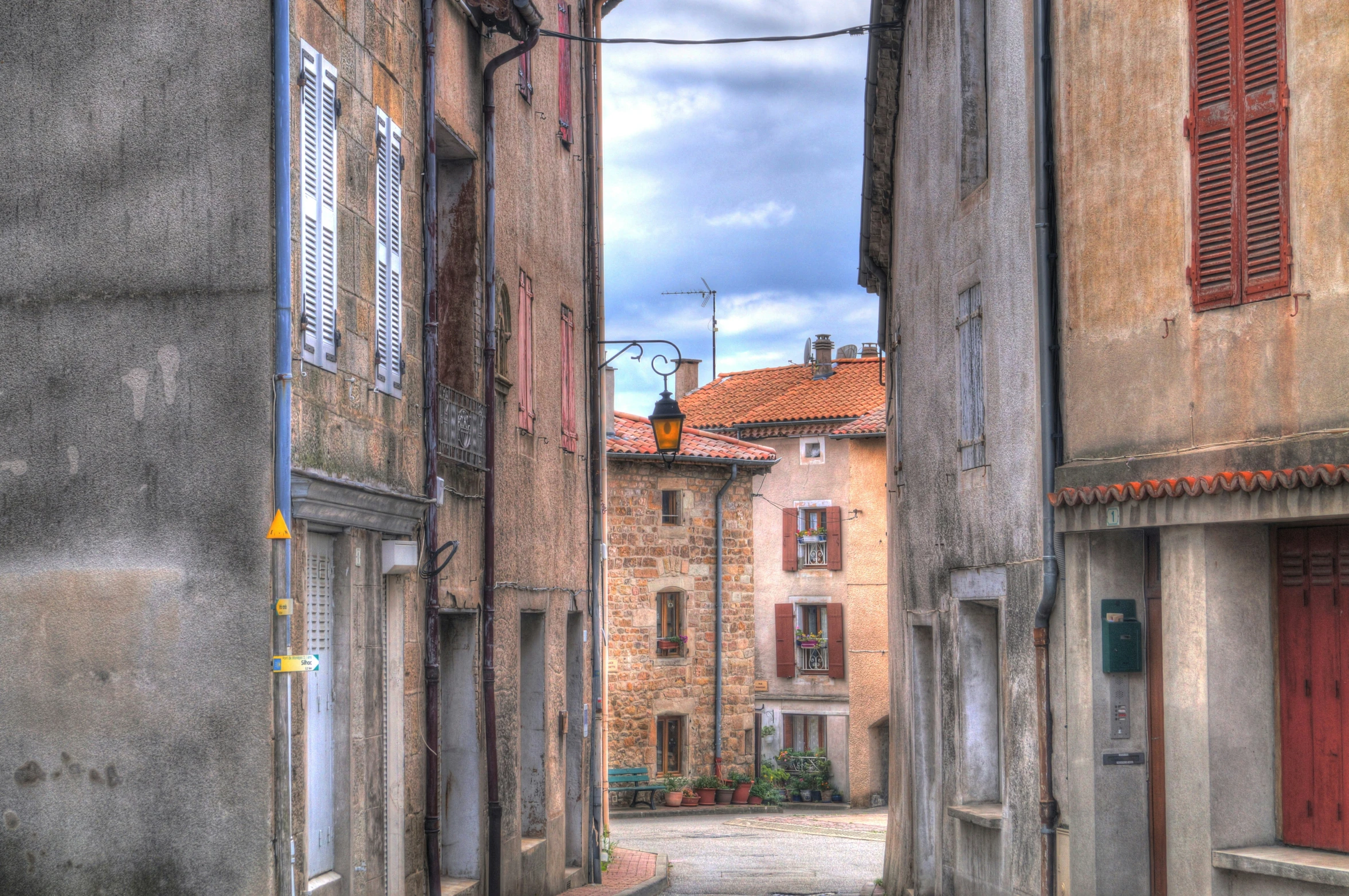 old cobblestones lined up against an alley with shutters