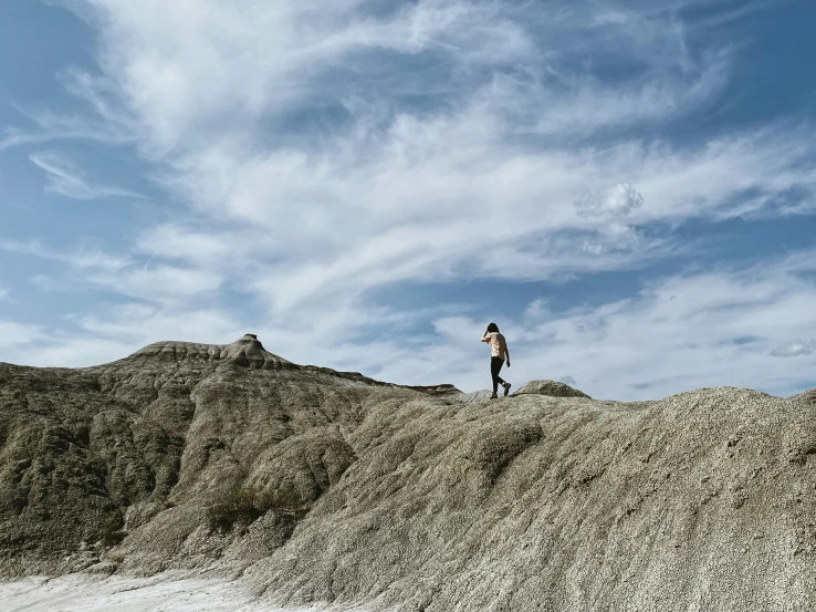 person standing on top of a large mound of sand