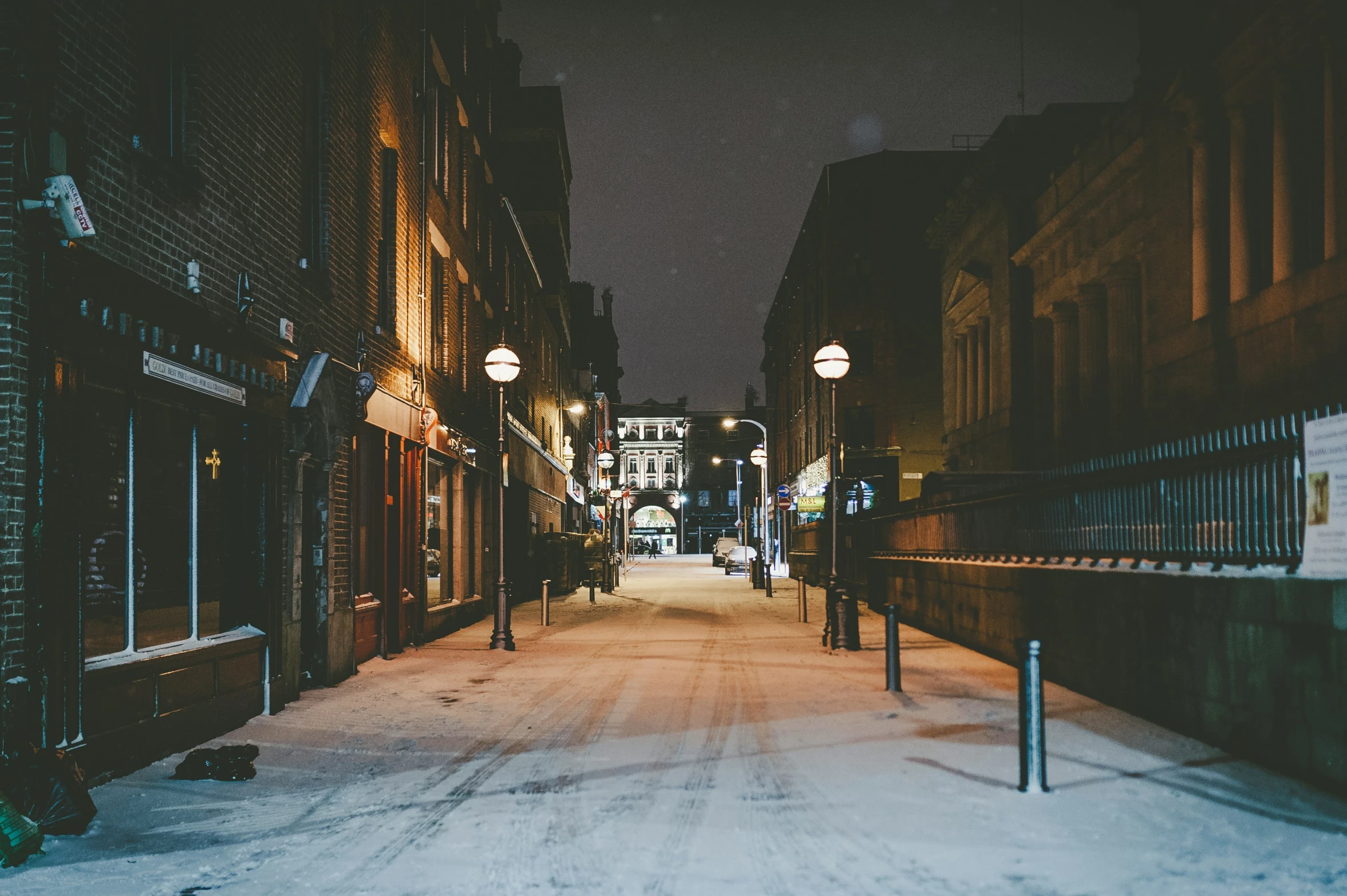 the snowy streets have buildings on either side