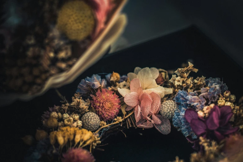 a wreath is full of dried flowers on the table