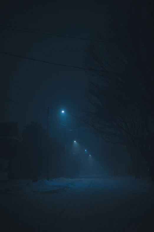 a dark city street is lit up by street lights