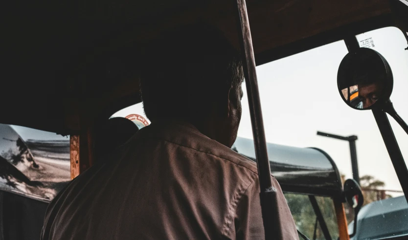 the back view of a man in the driver's seat of a bus