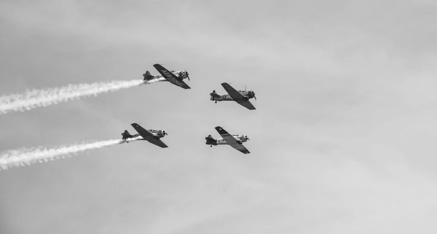 four jets flying in formation against a cloudy sky