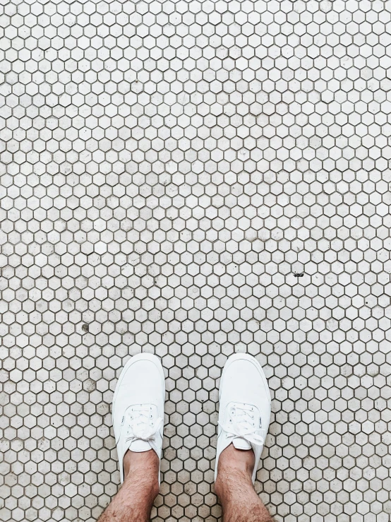 a persons foot on a floor with circles and spots