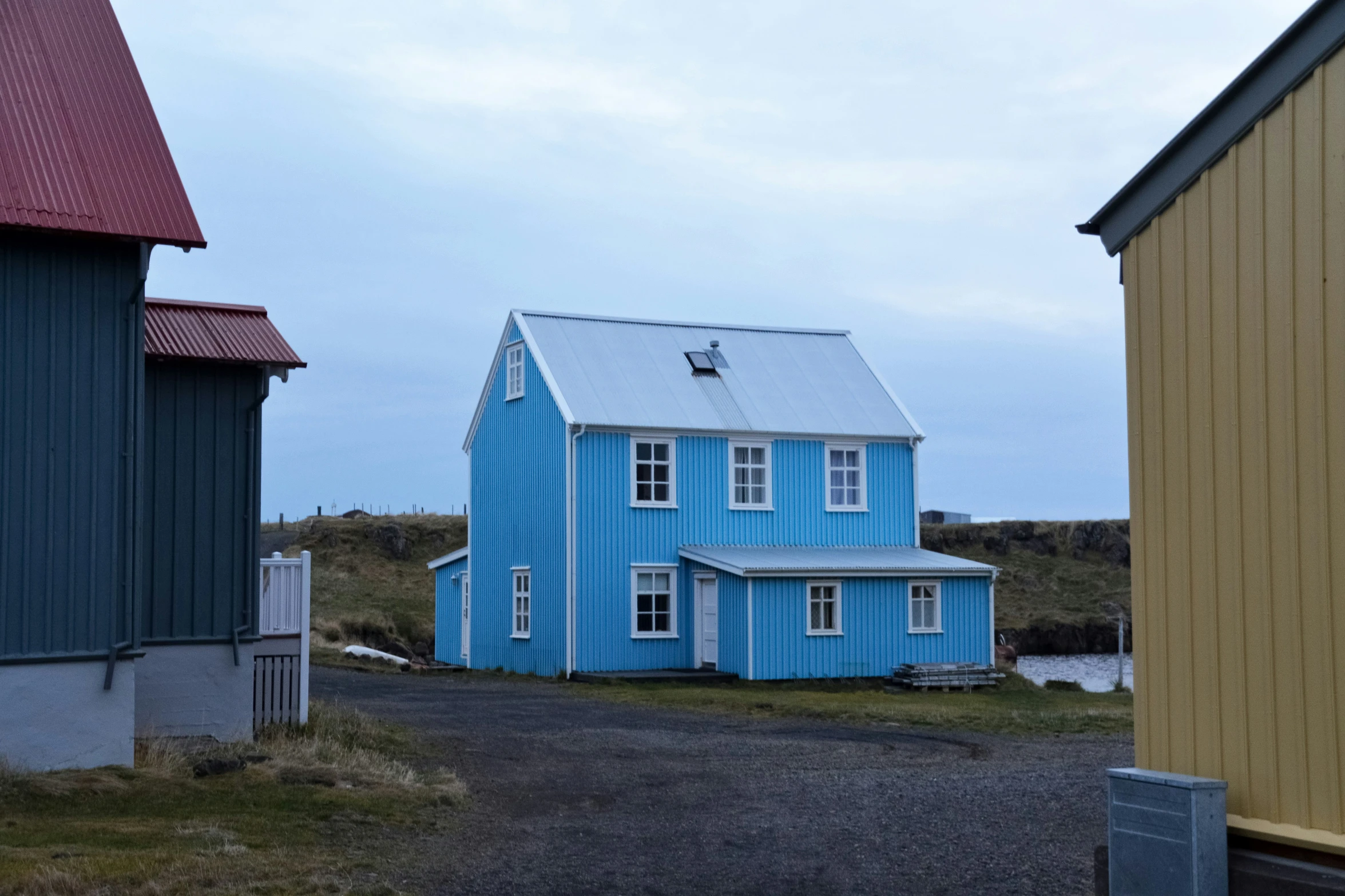 a blue house near a brown house with a door