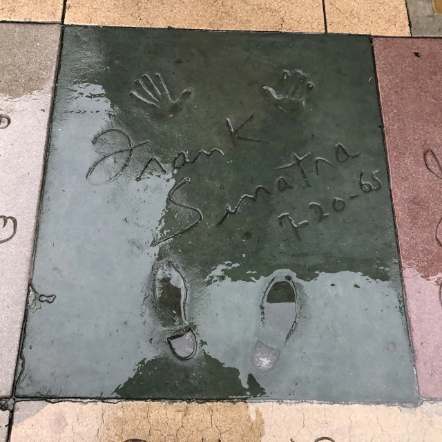 some writing on a sidewalk with a person walking next to it