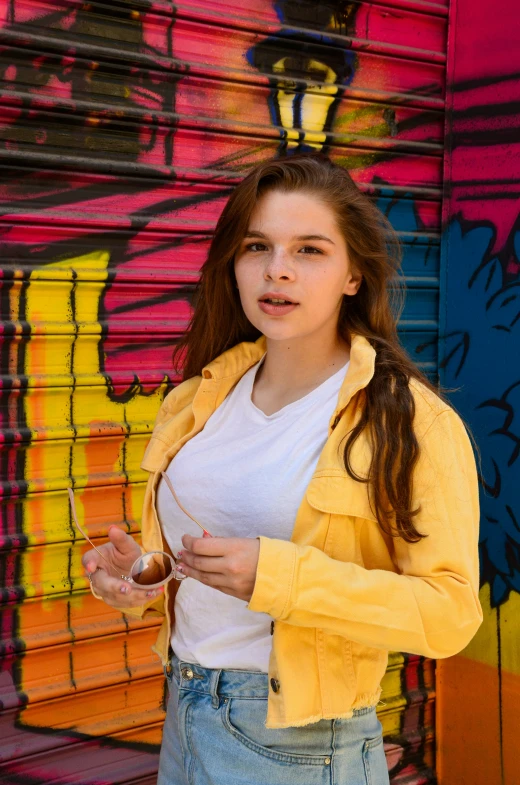 a girl poses in front of a colorful wall
