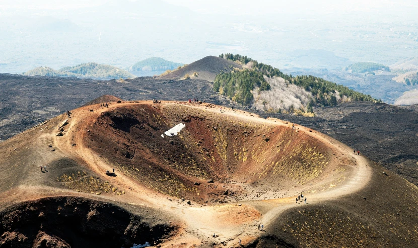 a mountain side with an upside down white bird on top