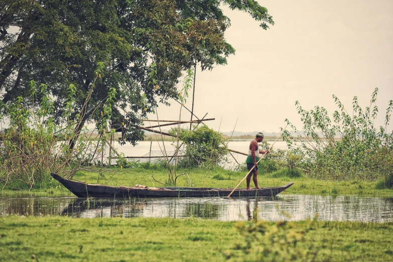 a man in a boat with sticks on the water