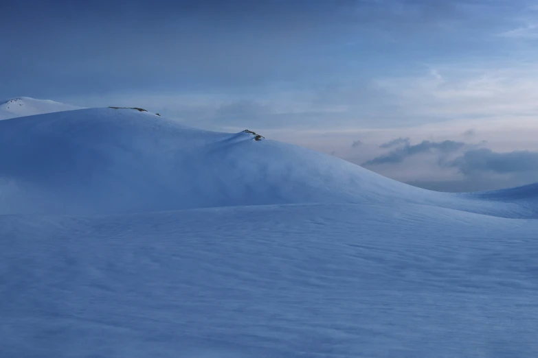 the mountains are covered in white snow as three people ski across