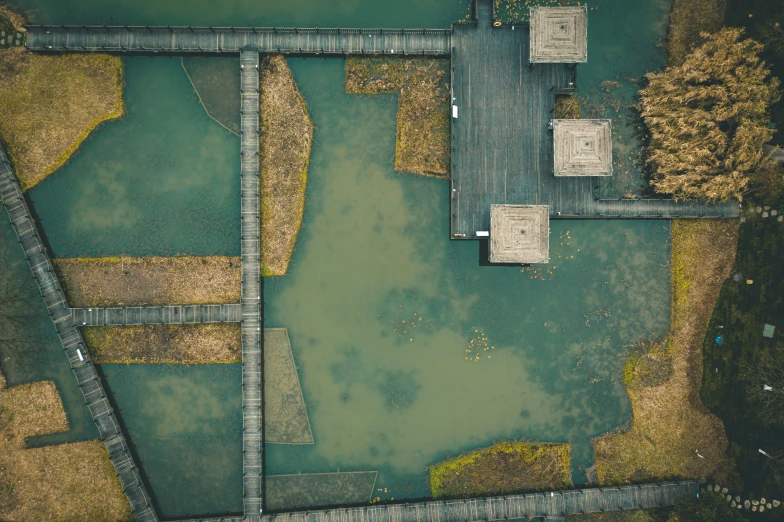 an aerial view of a paved road running across a water - covered field