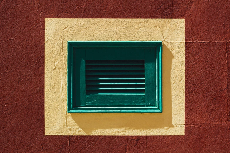 the green window on top of the brick wall