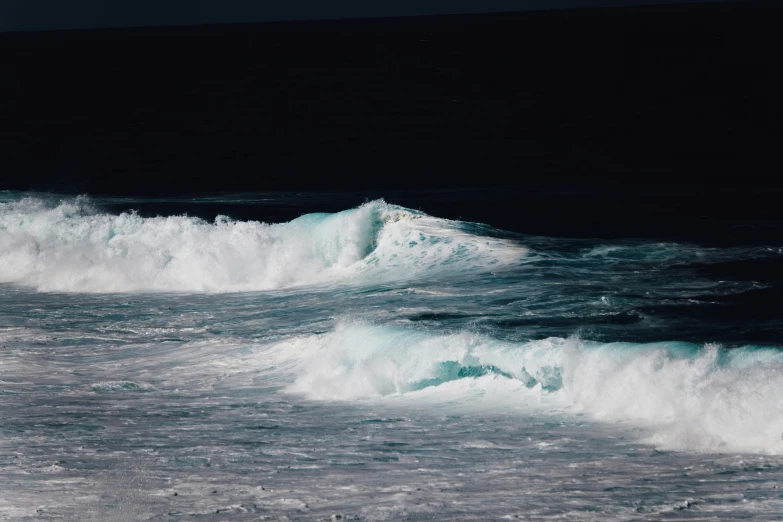 an ocean scene with a man walking on the beach with waves